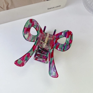 Detail of colorful acetate butterfly hair claw with red, green, and purple mosaic marble patterns