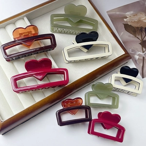 Chic heart pattern acetate hair claws in various colors and sizes on a display tray