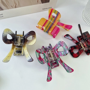 Set of colorful acetate bow hair claws in tortoiseshell, rainbow, and plaid patterns