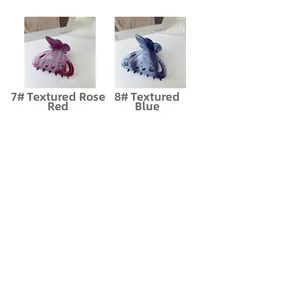 Détail de pinces à cheveux papillon rose et bleu avec strass et texture en acétate