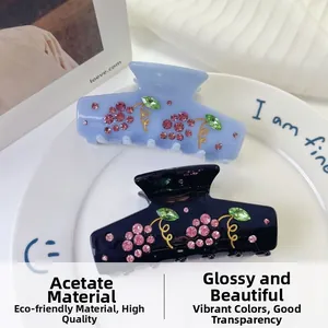 Detailed view of the acetate shark hair claw with sparkling rhinestone grape motif patterns