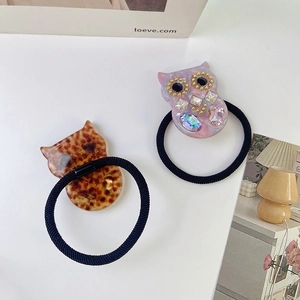 Dettaglio degli elastici per capelli a gufo in resina tartarugata e marmo rosa