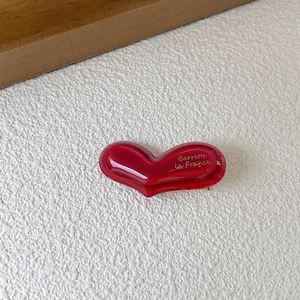 Close-up of red heart acetate hair clip with gold Barrette La France text engraving