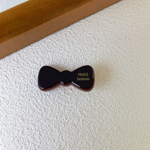 Dettaglio del fermaglio per capelli in acetato con scritta dorata France Handmade