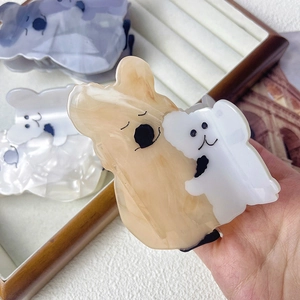 Detail showing high-quality acetate koala hair claw clips in yellow and purple marble finish