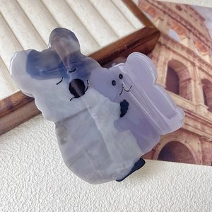 Detail of cute grey acetate koala hair claw clip with marbled texture on tray