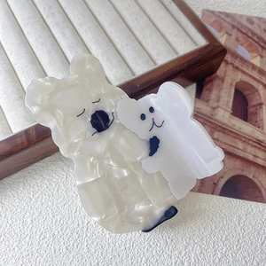 Close-up of cute koala acetate hair claw clip with pearlescent texture on beige tray