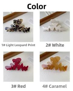 Dettaglio macro di pinze per capelli a cuore in leopardo, bianco, rosso e caramello