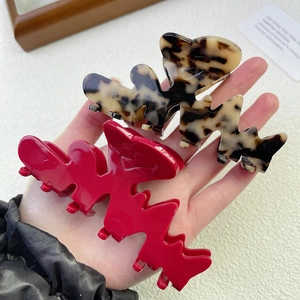 Dettaglio molletta per capelli rossa lucida e leopardata in acetato per acconciature