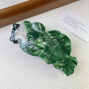 Détail d'une pince à cheveux feuille de lotus vert forêt avec chat et strass