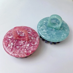 Close-up of pink and blue acetate scalp massage brushes with ergonomic finger ring handles