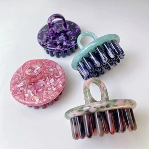 Macro detail of high-quality acetate hair massage combs in four elegant marble patterns