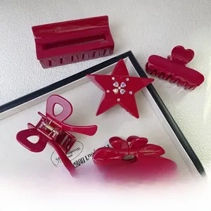 Set of five wine red acetate hair claws with rhinestones in a display tray for styling