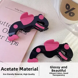 Détails de la pince à cheveux en acétate bicolore noir et rose avec motif cœur