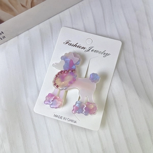 Pinza para pelo de caniche morado irisado con strass rosas en tarjeta de soporte