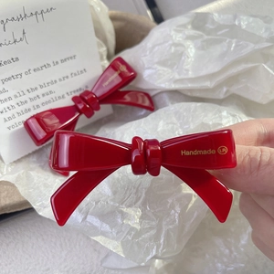 Elegant red acetate bow hair clip with gold Handmade LR engraving on white background