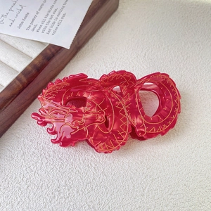 Detail of red Chinese dragon hair claw clip with golden outlines on vintage card