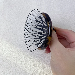 Détail de la base motif écaille de tortue et picots massants de la brosse à cheveux pneumatique