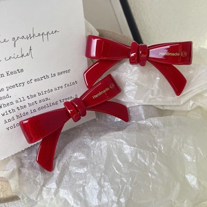 Elegant red acetate bow hair clips with gold handmade lettering in vintage style