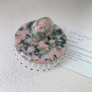 Détail de la brosse à cheveux en acétate marbré avec poignée en anneau ergonomique
