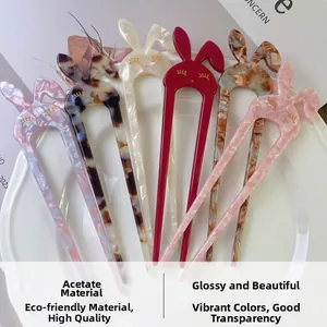 Close-up of cute rabbit-shaped acetate U-shaped hairpins in various colors on a white plate
