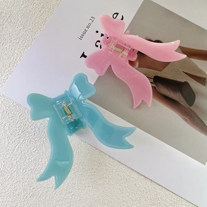 Pinces à cheveux papillon rose et bleu clair sur magazine avec un design élégant