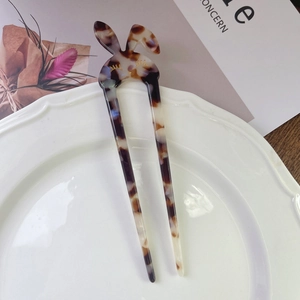 Detail of tortoise shell acetate rabbit hair pin with U-shaped fork on a white plate