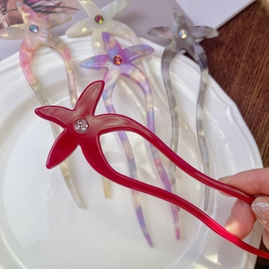 Détail d'épingles à cheveux étoile de mer en acétate et strass en rouge, violet et blanc