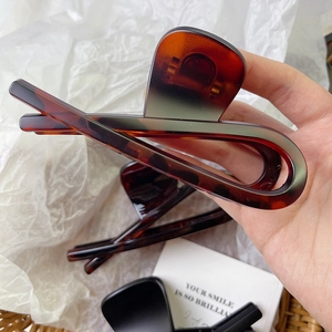 Close-up of a large tortoiseshell hair claw clip with brown and grey gradient resin finish