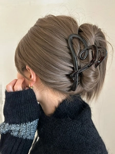 Large irregular heart-shaped hair claw in translucent dark tea brown on long hair