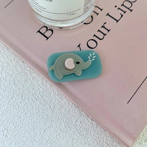 Detailed view of a cute gray elephant charm on a light blue hair clip base for girls