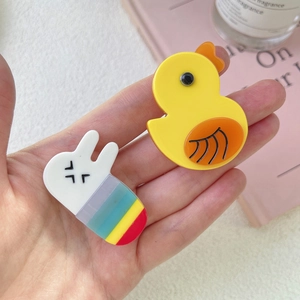 Detail of cute acrylic rabbit and duck hair clips with colorful rainbow stripes
