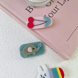 Close-up of cute acrylic animal hair clips featuring cherry, elephant, and rabbit designs