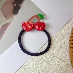 Close-up of cherry acetate hair tie with sparkling rhinestones on red resin fruit charm