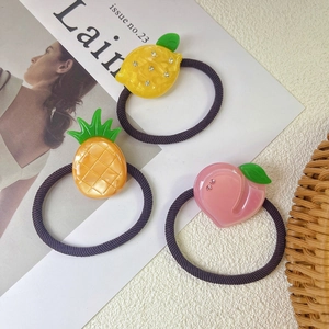 Detailed view of handmade fruit charms including lemon and peach on high-elastic hair ties