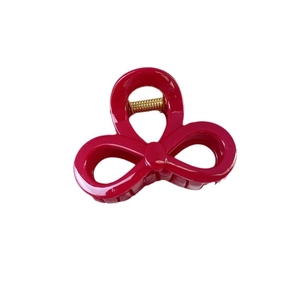 Vibrant rose red hollow butterfly hair claw clip with golden metal spring on white background
