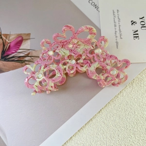 Detail of pink marble acetate flower hair claw clip with faux pearl center embellishment