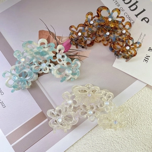 Elegant cutout acetate flower hair claw clips with rhinestones in marble and cream colors