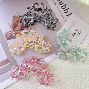 Elegant hollow floral acetate hair claws with marble texture and pearl center accents