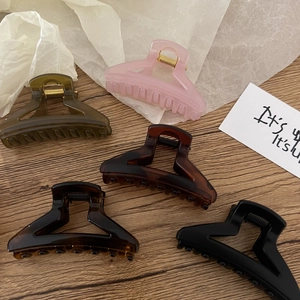 Five-piece set of matte triangle hair claws in multiple colors on a wooden surface