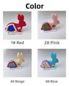 Quatre figurines de lapins en acrylique coloré rouge, rose, beige et bleu avec touches dorées