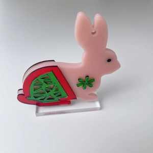 Détail de la figurine lapin rose en acrylique avec motif pastèque et support