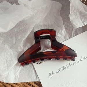Close-up of vintage amber leopard pattern hair claw clip with durable metal spring