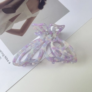 Detail of hollow butterfly acetate hair claw clip with colorful pearlescent texture
