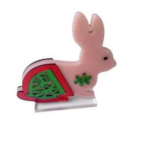Figurine de lapin rose en acétate avec trèfle vert et motifs géométriques variés