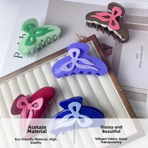 Détail de pinces à cheveux en acétate bicolore au design de nœud papillon chic