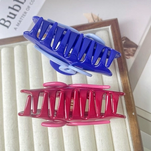Vue détaillée de grandes pinces à cheveux bleues et magenta sur un plateau