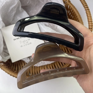 Pinze per capelli geometriche spesse di alta qualità nero lucido e tartaruga in mano
