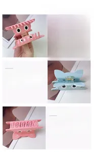 Dettaglio di fermagli per capelli a gatto in acetato rosa e blu con motivi a cartone