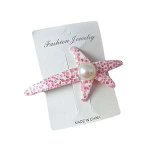 Barrette étoile de mer en acétate avec perle et texture marbre rose sur fond blanc